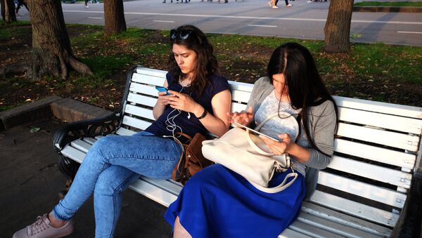 Девушки с телефонами в одном из парков Москвы. Архивное фото - Sputnik Кыргызстан