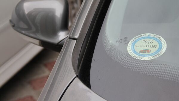 Наклейка об уплате налога на движимое имущество в лобовом стекле автомобиля. Архивное фото - Sputnik Кыргызстан