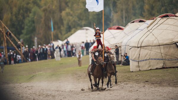 Мальчик на плечах всадников с флагом на руках в рамках Всемирных игр кочевников на джайлоо Кырчын - Sputnik Кыргызстан