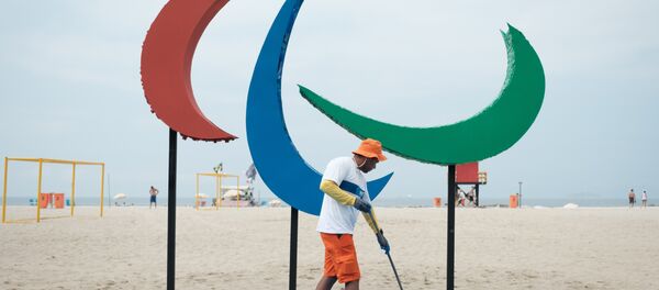Рабочий подметает площадь перед открытием летних паралимпийских игр 2016 на пляже Копакабана в Рио-де-Жанейро - Sputnik Кыргызстан