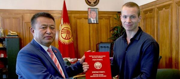 Торага Жогорку Кенеша Чыныбай Турсунбеков награждает россиянина Юрия Лугвина почетной грамотой парламента за проявленное мужество и спасение кыргызстанок при пожаре в московской типографии - Sputnik Кыргызстан