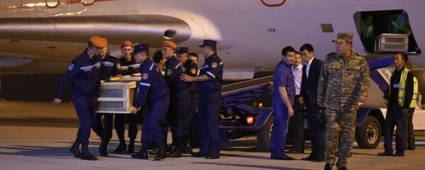 Сотрудники МЧС КР выгружают тела погибших кыргызстанок в пожаре в Москве доставленные спецрейсом. Архивное фото - Sputnik Кыргызстан