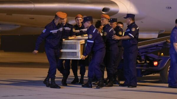 Сотрудники МЧС КР выгружают тела погибших кыргызстанок в пожаре в Москве доставленные спецрейсом - Sputnik Кыргызстан