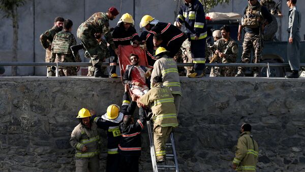 Спасатели и пожарные спускают по лестнице пострадавшего при взрыве в Кабуле - Sputnik Кыргызстан
