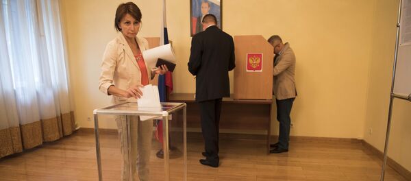 Гражданка России отпускает бюллетень в урну, в посольтве РФ и Кыргызстане в рамках проведения выборов в Государственную Думу России - Sputnik Кыргызстан