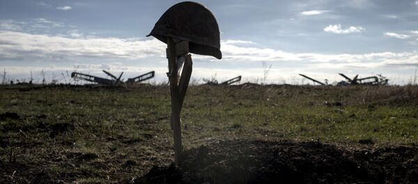 Каска погибшего солдата на могиле. Архивное фото - Sputnik Кыргызстан