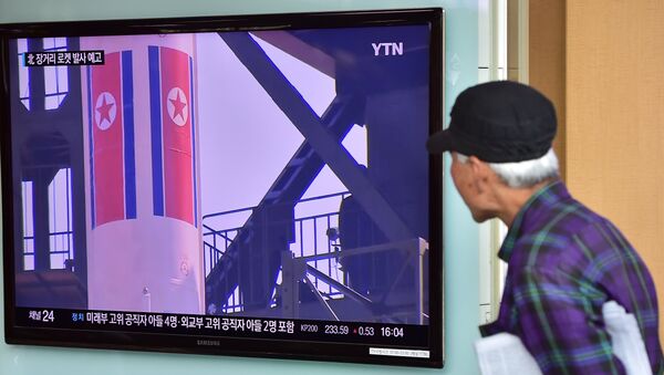 Мужчина смотрит трансляцию запуска ядерной ракеты в Северной Кореи - Sputnik Кыргызстан