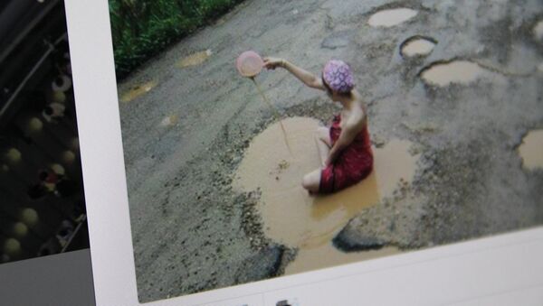 Снимок со страницы пользователя Twitter. Модель из Таиланда купается в луже посередине дороги - Sputnik Кыргызстан