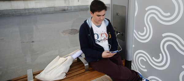 Молодой человек заряжает телефон на остановке общественного транспорта. Архивное фото Молодой человек заряжает телефон на остановке общественного транспорта. Архивное фото - Sputnik Кыргызстан