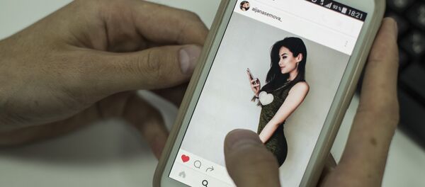 Пользователь смотрит страницу Instagram Айжан Асемовой с экрана смартфона - Sputnik Кыргызстан