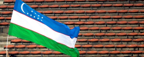 Мужчина несет национальный флаг Узбекистана. Архивное фото - Sputnik Кыргызстан