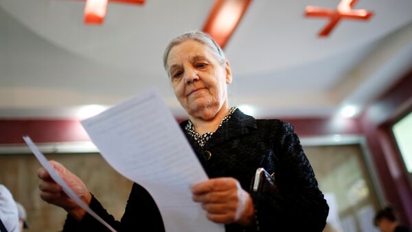 Женщина изучает бюллетень во время парламентских выборов в Тбилиси, Грузия - Sputnik Кыргызстан
