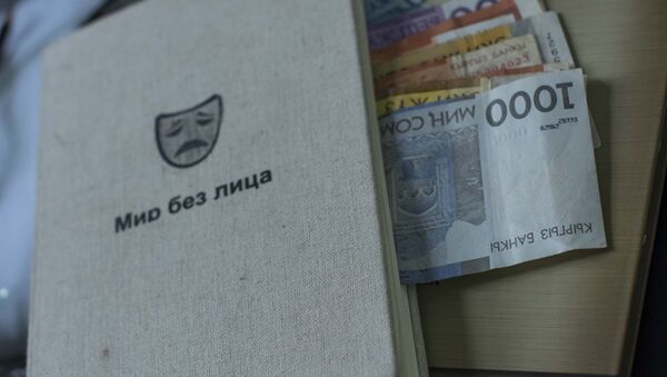 Сомовые купюры разного номинала и блокнот на столе. Архивное фото - Sputnik Кыргызстан