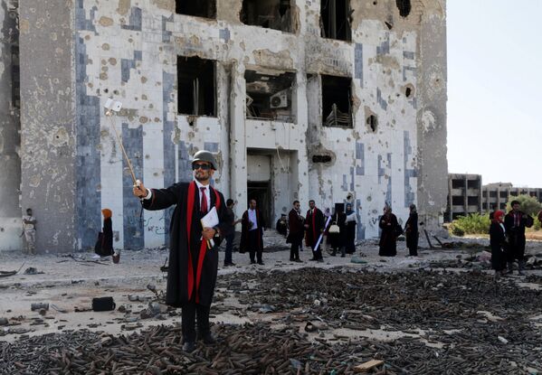 Церемония выпуска студентов перед разрушенным в ходе войны зданием университета Бенгази в Ливии - Sputnik Кыргызстан