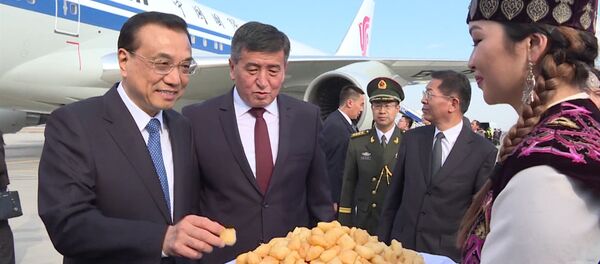 Кытайдын премьерин кучак толо гүл жана боорсок менен тосуп алышты - Sputnik Кыргызстан