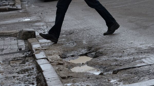 Мужчина идет по разбитому асфальту. Архив  - Sputnik Кыргызстан