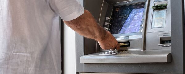 Банкоматтан акча алып жаткан адамдын архивдик сүрөтү Банкоматтан акча алып жаткан адамдын архивдик сүрөтү - Sputnik Кыргызстан