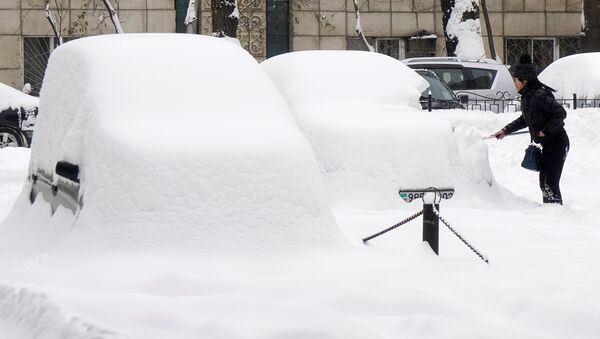 Женщина убирает снег с автомобиля после сильного снегопада. Архивное фото - Sputnik Кыргызстан