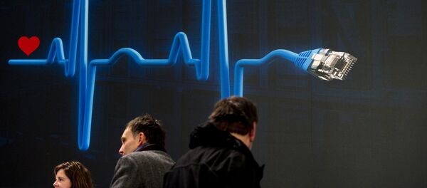 Посетители ярмарки IT технологий на фоне плаката в виде сердечного пульса из сетевого кабеля. - Sputnik Кыргызстан