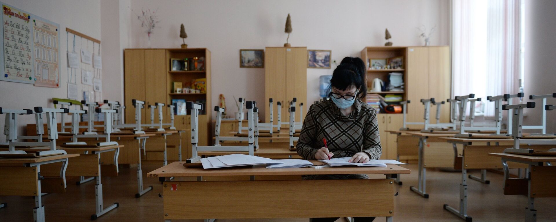 Учительница начальных классов проверяет школьные тетради во время карантина в школе. Архивное фото - Sputnik Кыргызстан, 1920, 18.01.2022