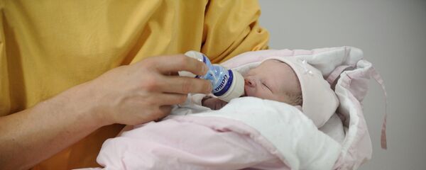 Женщина кормит новорожденного ребенка. Архивное фото Женщина кормит новорожденного ребенка. Архивное фото - Sputnik Кыргызстан