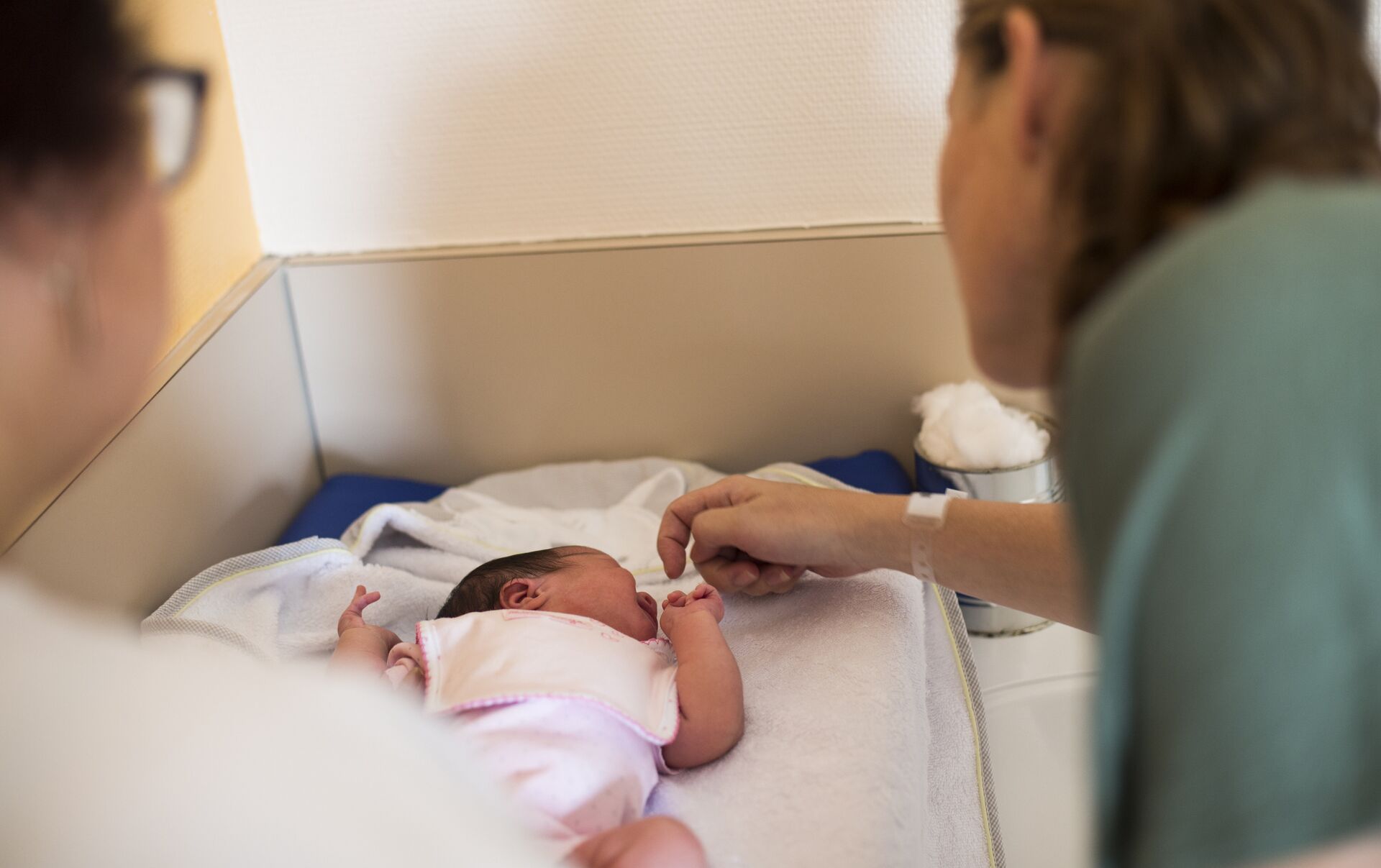 Медсестра и мать новорожденного ухаживают за ребенком 
