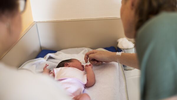 Мать новорожденного ухаживает за ребенком. Архивное фото - Sputnik Кыргызстан