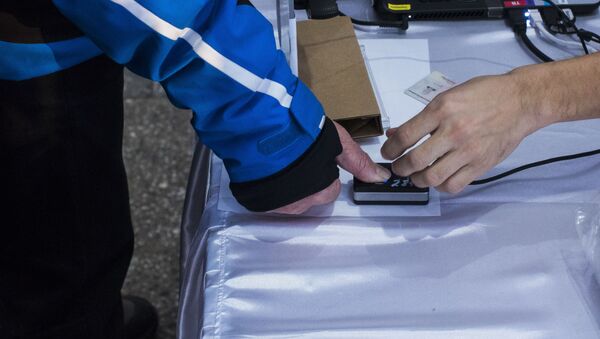 Проверка на биометрику во время голосования на выборах. Архивное фото - Sputnik Кыргызстан
