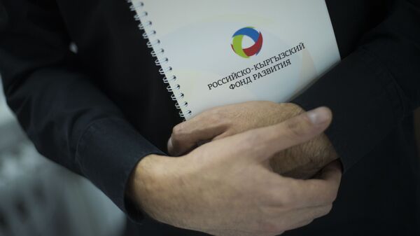 Мужчина держит папку с логотипом Российского-Кыргызского фонда развития (РКФР). Архивное фото - Sputnik Кыргызстан