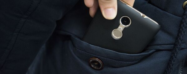 Чөнтөктөн телефон чыгарып жаткан адам. Архив - Sputnik Кыргызстан