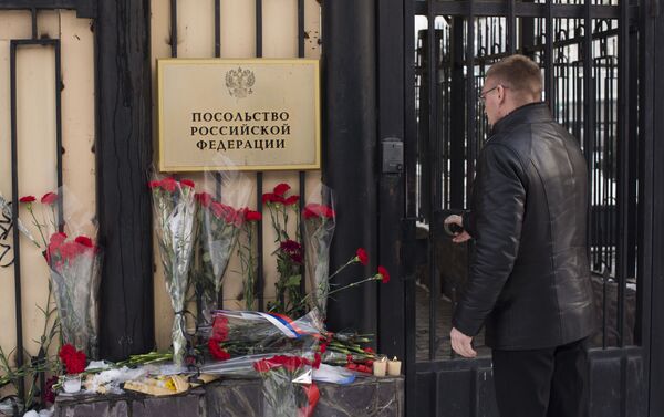 Кыргызстанцы несут цветы к посольству России в КР в память о погибших во время крушения самолета Минобороны РФ под Сочи - Sputnik Кыргызстан