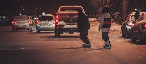 Сноубордисты катаются на досках по центральным улицам Бишкека во время снегопада - Sputnik Кыргызстан