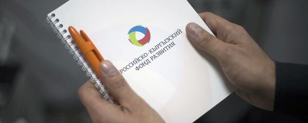 Мужчина держит папку с логотипом Российского-Кыргызского фонда развития (РКФР). Архивное фото - Sputnik Кыргызстан