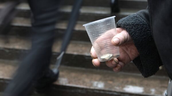 Попрошайка держит в руке стакан с мелочью. Архивное фото - Sputnik Кыргызстан
