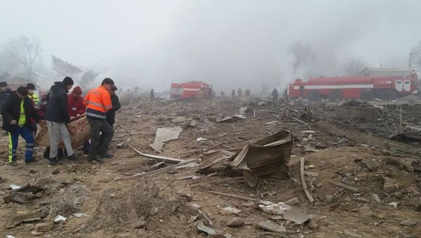 Спасатели и местные жители несут тело погибшего при крушении самолета Boeing-747 недалеко от аэропорта Манас - Sputnik Кыргызстан