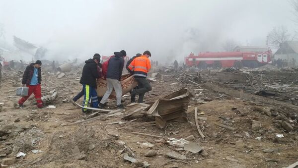 Спасатели и местные жители несут тело погибшего при крушении самолета Boeing-747 в селе Дача-Суу недалеко от аэропорта Манас - Sputnik Кыргызстан