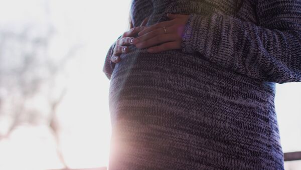 Беременная женщина держится за живот. Архивное фото - Sputnik Кыргызстан