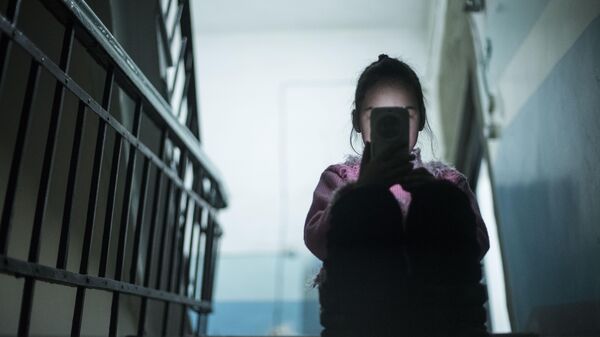 Девочка сидит со смартфоном в руке в подъезде. Архивное фото - Sputnik Кыргызстан