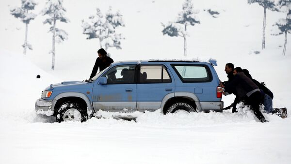 Мужчины толкают машину, который застрял в снегу на окраине Кабула - Sputnik Кыргызстан