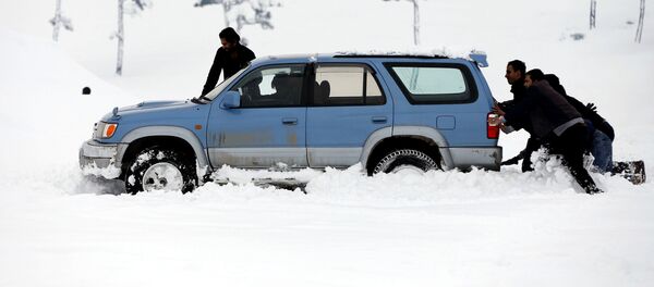 Мужчины толкают машину, который застрял в снегу на окраине Кабула Мужчины толкают машину, который застрял в снегу на окраине Кабула - Sputnik Кыргызстан