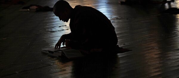 Буддийский монах читает книгу в монастыре - Sputnik Кыргызстан