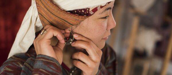 Сөйкө тагынып жаткан кыз. Архив - Sputnik Кыргызстан