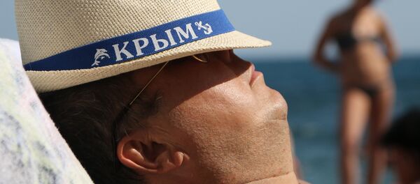 Мужчина отдыхающий на плаже в Крыму. Архивное фото - Sputnik Кыргызстан