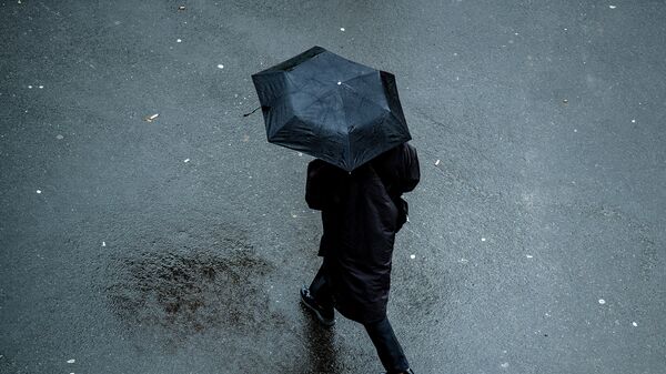 Человек с зонтом идет по улице. Архивное фото - Sputnik Кыргызстан