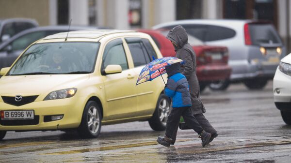 Женщина с ребенком переходят улицу во время дождя в Бишкеке. Архивное фото - Sputnik Кыргызстан
