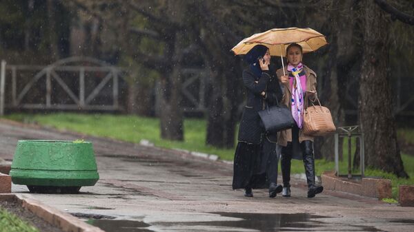 Девушки с зонтом во время дождливой погоды на одной из улиц Бишкека. Архивное фото - Sputnik Кыргызстан