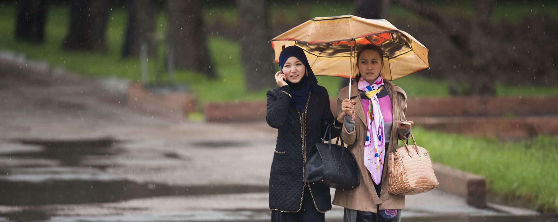Девушки идет во время дождя. Архивное фото - Sputnik Кыргызстан, 1920, 02.07.2023