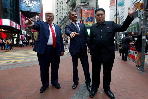 АКШнын президенти Дональд Трамптын, экс-президент Барак Обама жана Түндүк Корея лидери Ким Чен Ындын маскасын кийгендер Гонконгдун көчөлөрүн аралап басышты - Sputnik Кыргызстан