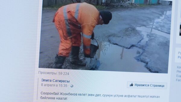 Снимок с социальной сети Facebook группы Элита Сатирасы. Дорожный работник асфальтируют трассу, несмотря на лужи в ямах - Sputnik Кыргызстан