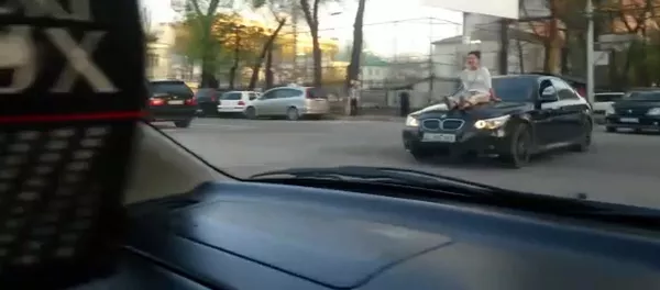 Девушка прокатилась на капоте автомобиля в Бишкеке - Sputnik Кыргызстан